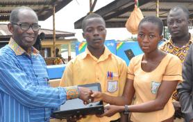 Mr Lee Ocran - Outgoing Minister of Education presenting a lap top to a beneficiary 